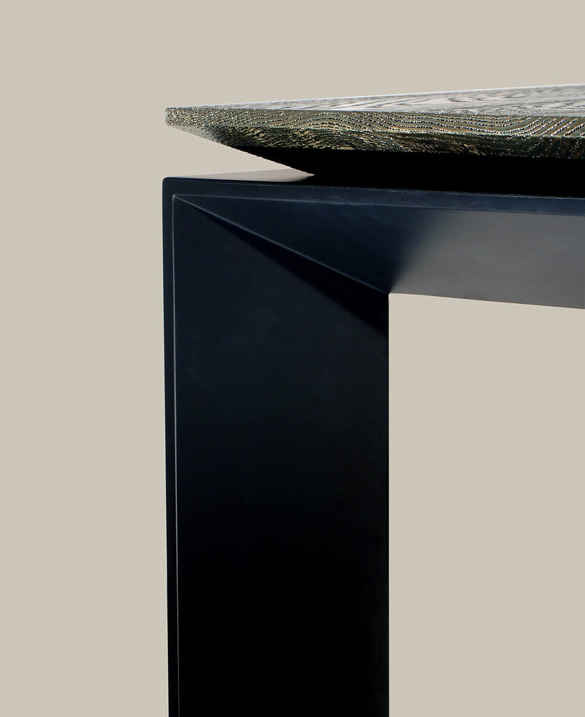 Cairo Table with sleek geometric base and textured stone or metal top