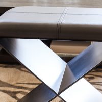 Modern upholstered Santorini Stool with a sleek metal X-shaped base for stylish seating