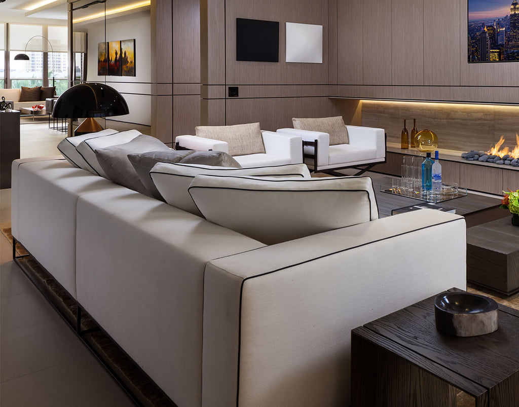 Glasgow Sofa with light-colored sectional design, dark piping, and cozy throw pillows