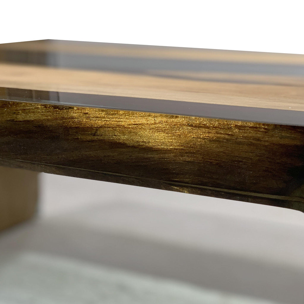Wooden tray with a golden rim on Aquamarine Walnut Wood Waterfall Coffee Table featuring walnut wood design