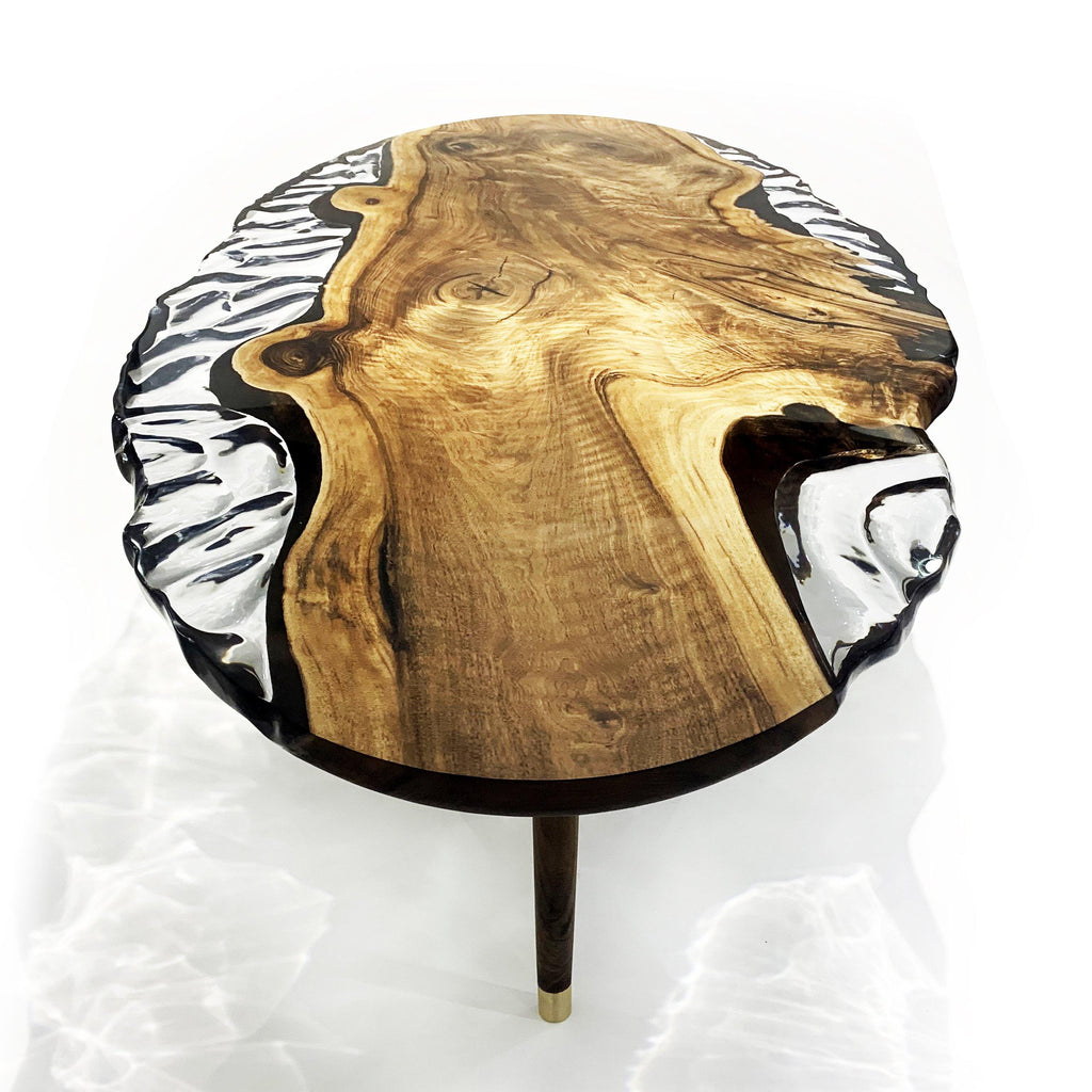 Walnut wood wavy coffee table with clear resin, black zebra-stripe accents, and brass legs