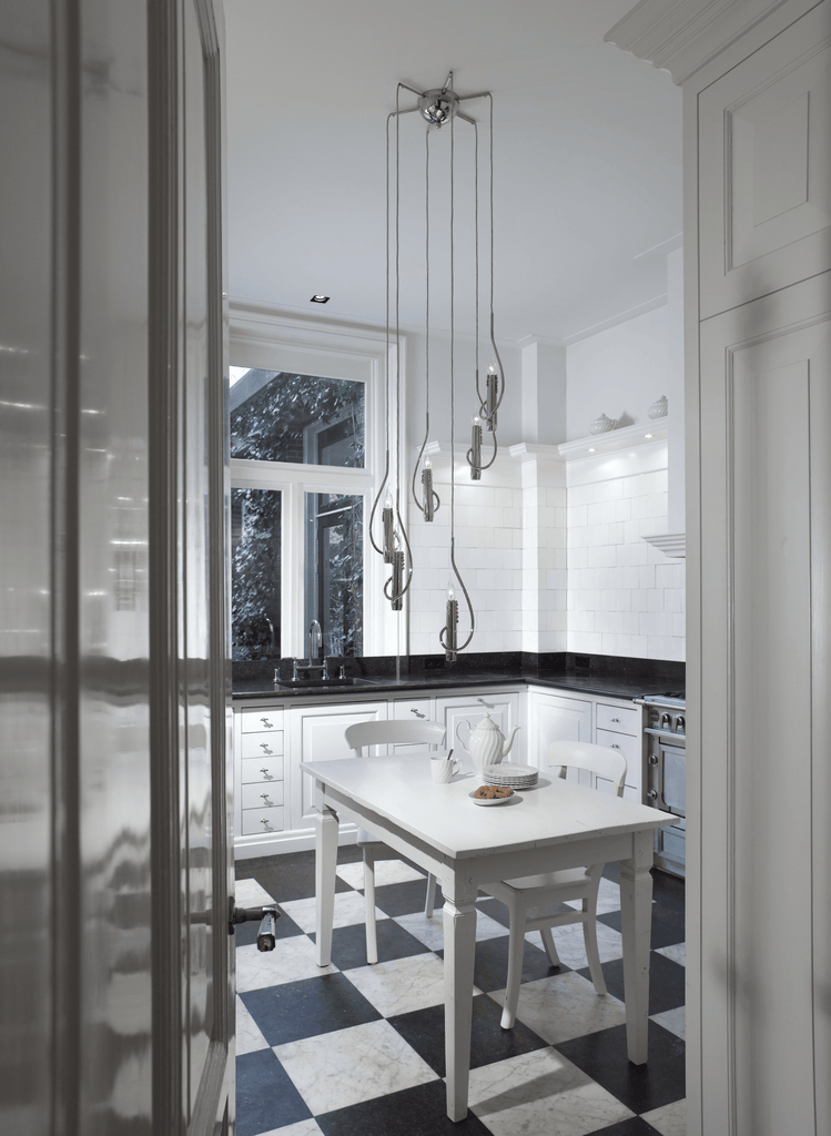 Modern white kitchen with black and white checkerboard flooring and floating candles hanging lamp