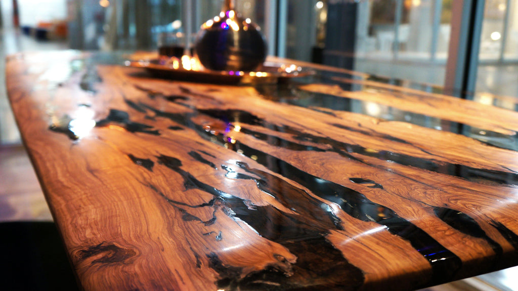 Giona Olive Dining Table with glossy dark resin inlay and wooden surface