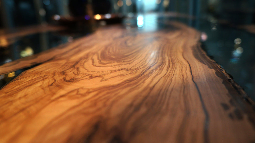 Polished wooden bar top with distinct grain patterns on Giona Olive Dining Table