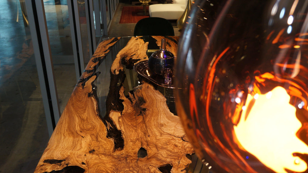 Glowing amber glass lamp on Giona Olive Dining Table for elegant olive dining ambiance