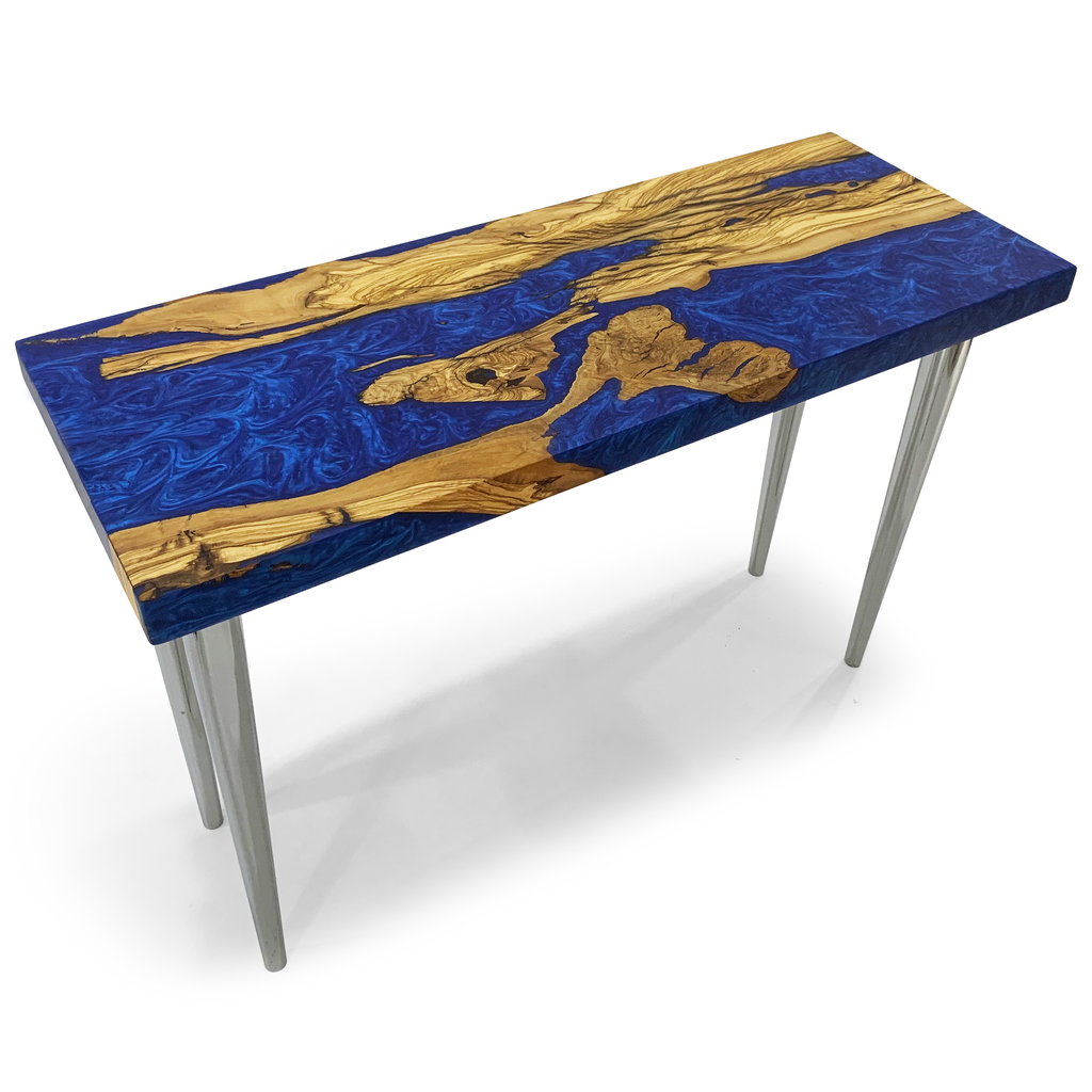 A rectangular console table with a blue epoxy resin and natural wood top, supported by four slender, light-colored legs.