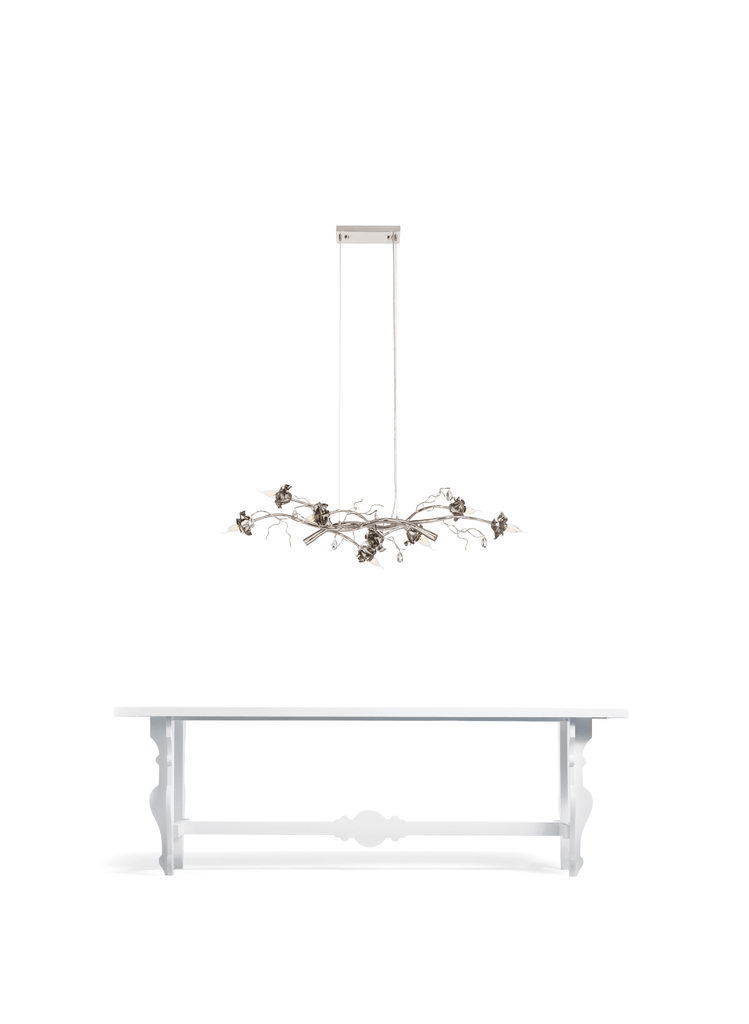 White console table with a La Vie En Rosa hanging lamp and decorative metal chandelier