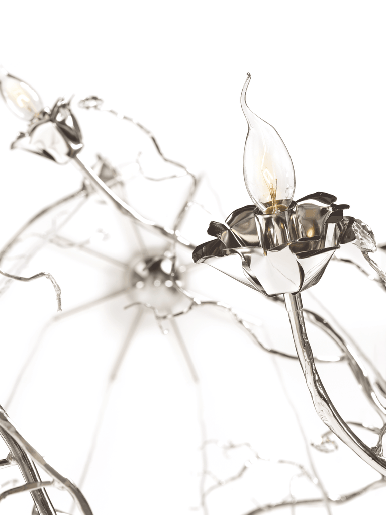 Silver-colored chandelier with candle-shaped bulbs from La Vie En Rosa Wall Lamp collection