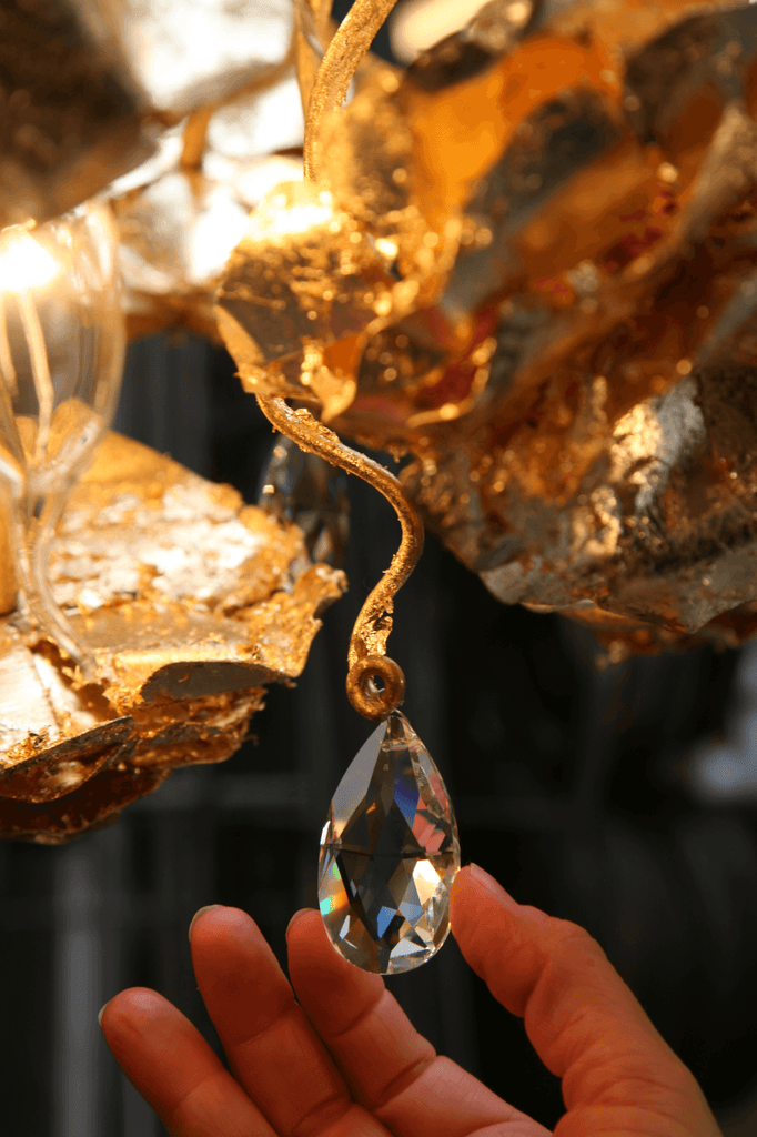 Hand touching sparkling crystal teardrop pendant on Love You Love You Not Chandelier Oval