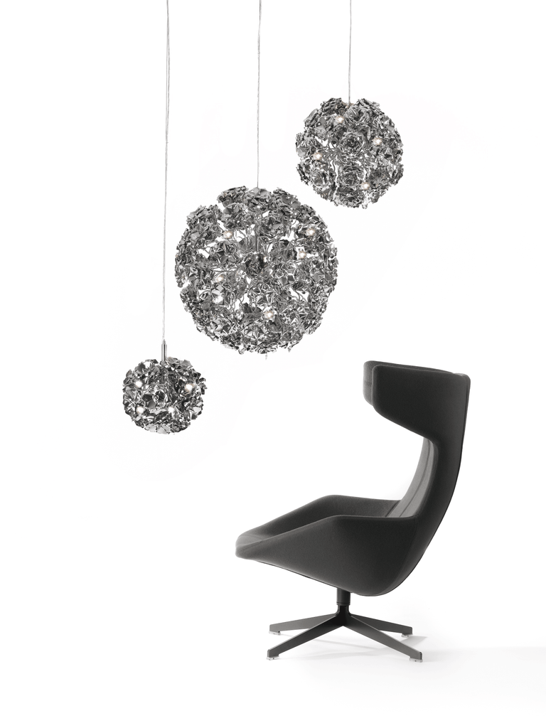 Modern dark grey upholstered swivel armchair with a high back and intricate hanging lamp