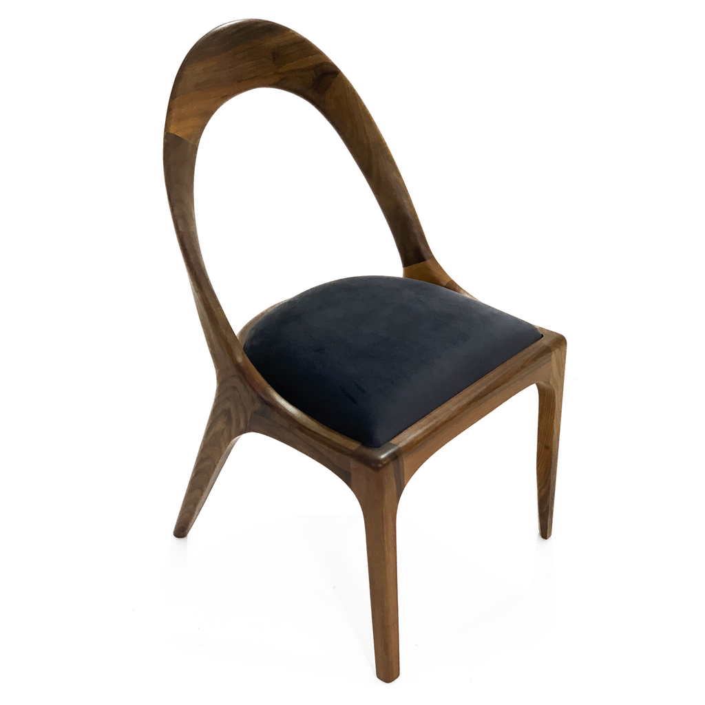 Nyks Dining Chair with wooden frame, curved backrest, and dark upholstered seat