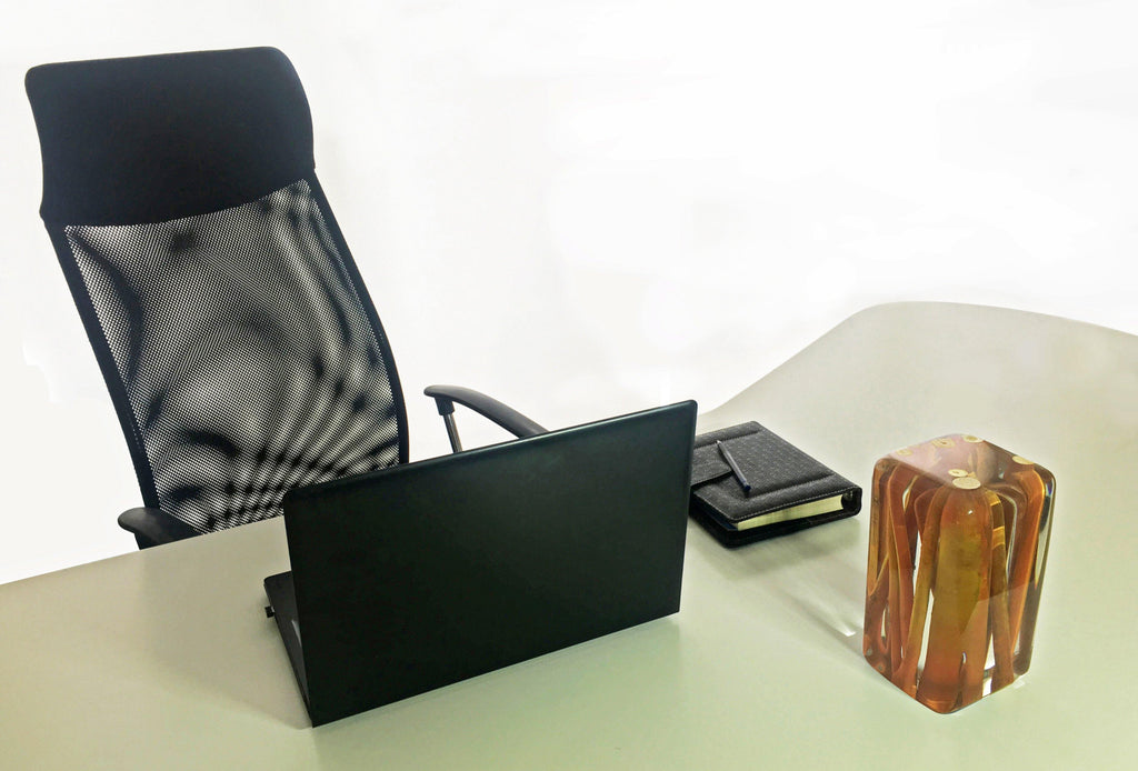Black mesh office chair and laptop setup with Orange Branches Cube decor for modern workspace