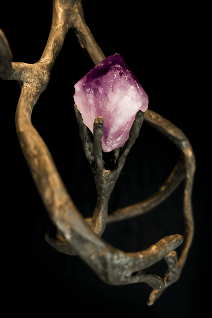 Raw amethyst crystal held by bronze intertwined hands in Orpheus Amethyst Hanging Lamp display