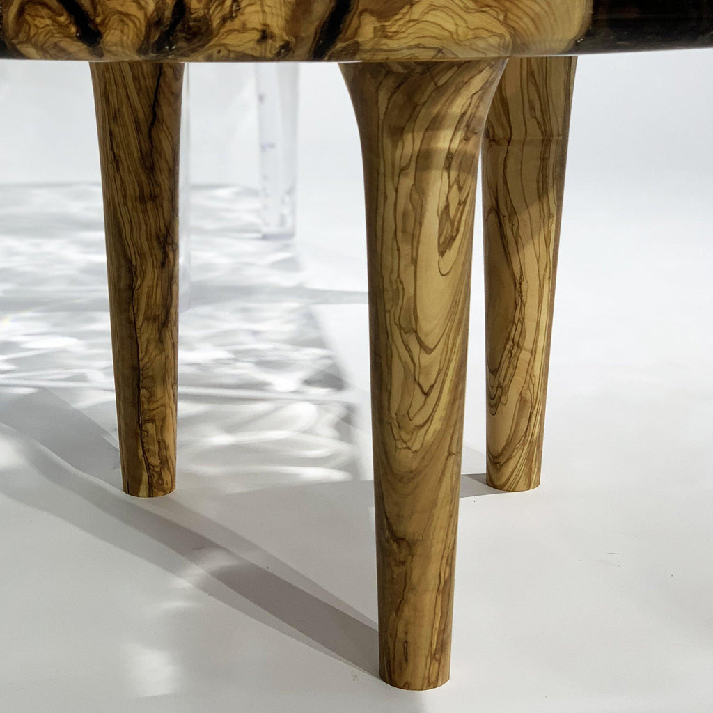 Tyro Olive Wood Wavy Coffee Table with four wooden legs and unique grain patterns